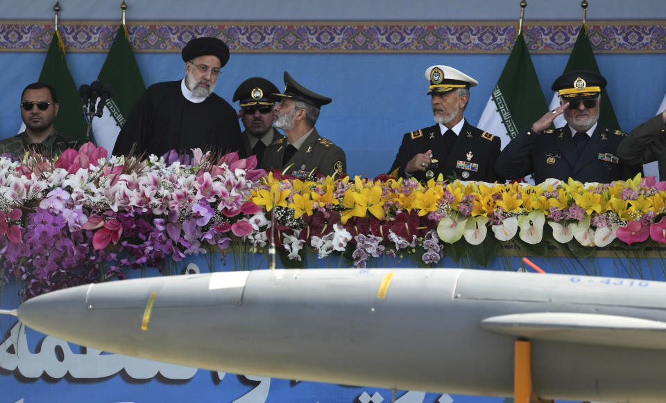 Iranian President Ebrahim Raisi, second left, listens to the army commander Gen. Abdolrahim Mousavi as he reviews an army parade commemorating Army Day while a missile is carried on a truck in front of the mausoleum of the late revolutionary founder Ayatollah Khomeini just outside Tehran, Iran, Tuesday, April 18, 2023. President Raisi reiterated threats against Israel while though he stayed away from criticizing Saudi Arabia as Tehran seeks a détente with the kingdom. (AP Photo/Vahid Salemi)