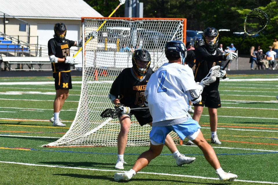 Moorestown senior goalie TJ Mindnich and junior Jack Bertino eye up Shawnee junior Nick Goeller