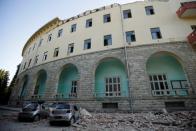 Destroyed cars stand next to a damaged building after an earthquake in Tirana