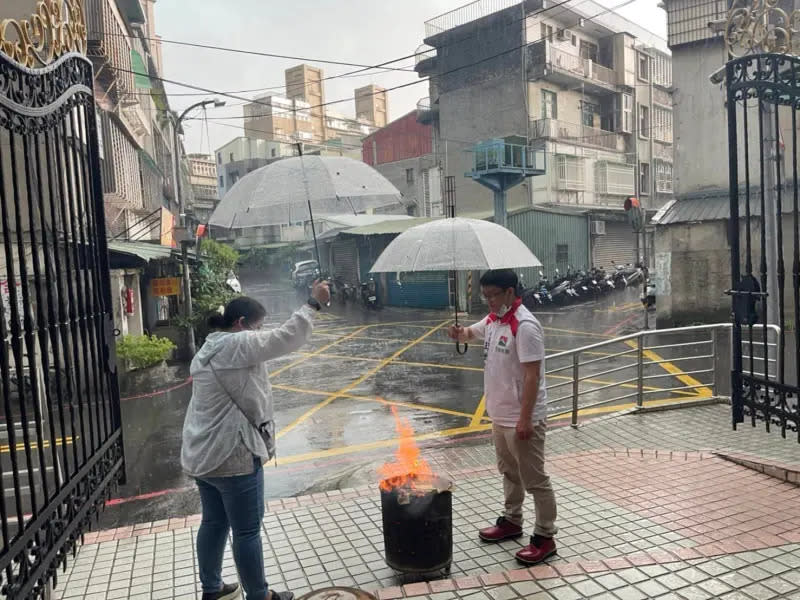 ▲信義房屋以「先義後利」精神推動社區服務，民俗月全員出動協助社區普渡，新莊公園店於支援時碰上大雨，同仁主動協助撐傘避免金爐熄滅。（圖／資料照片）