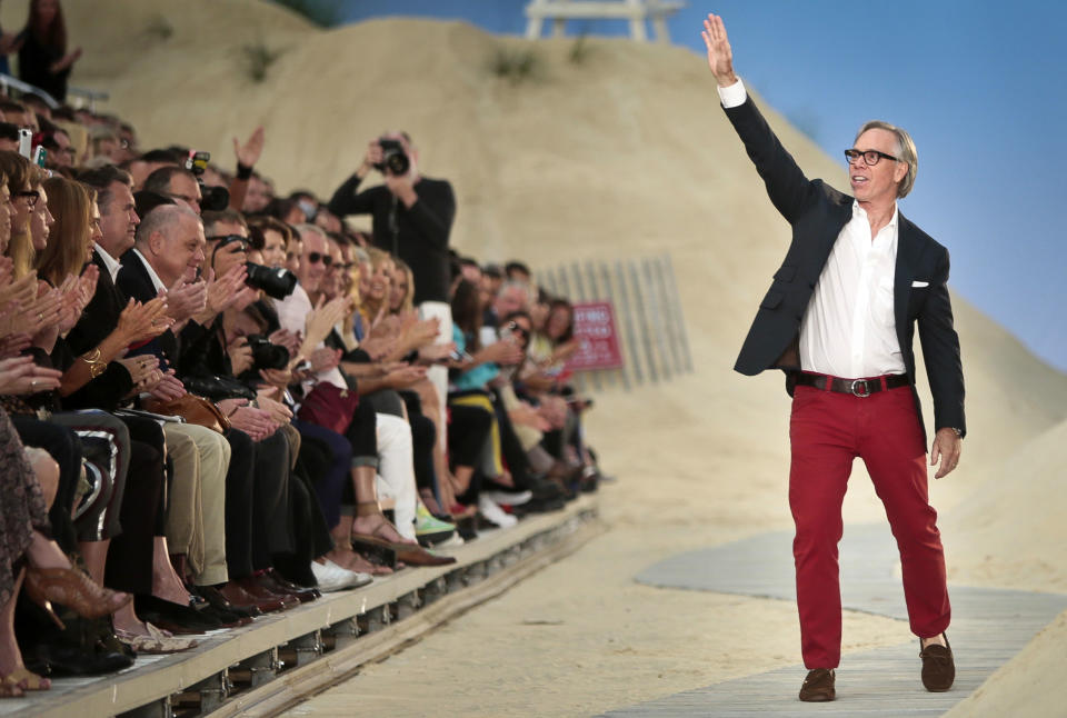 Fashion designer Tommy Hilfiger waves as he reacts to applause following the show for his Spring 2014 collection on Monday, Sept. 9, 2013 in New York. (AP Photo/Bebeto Matthews)