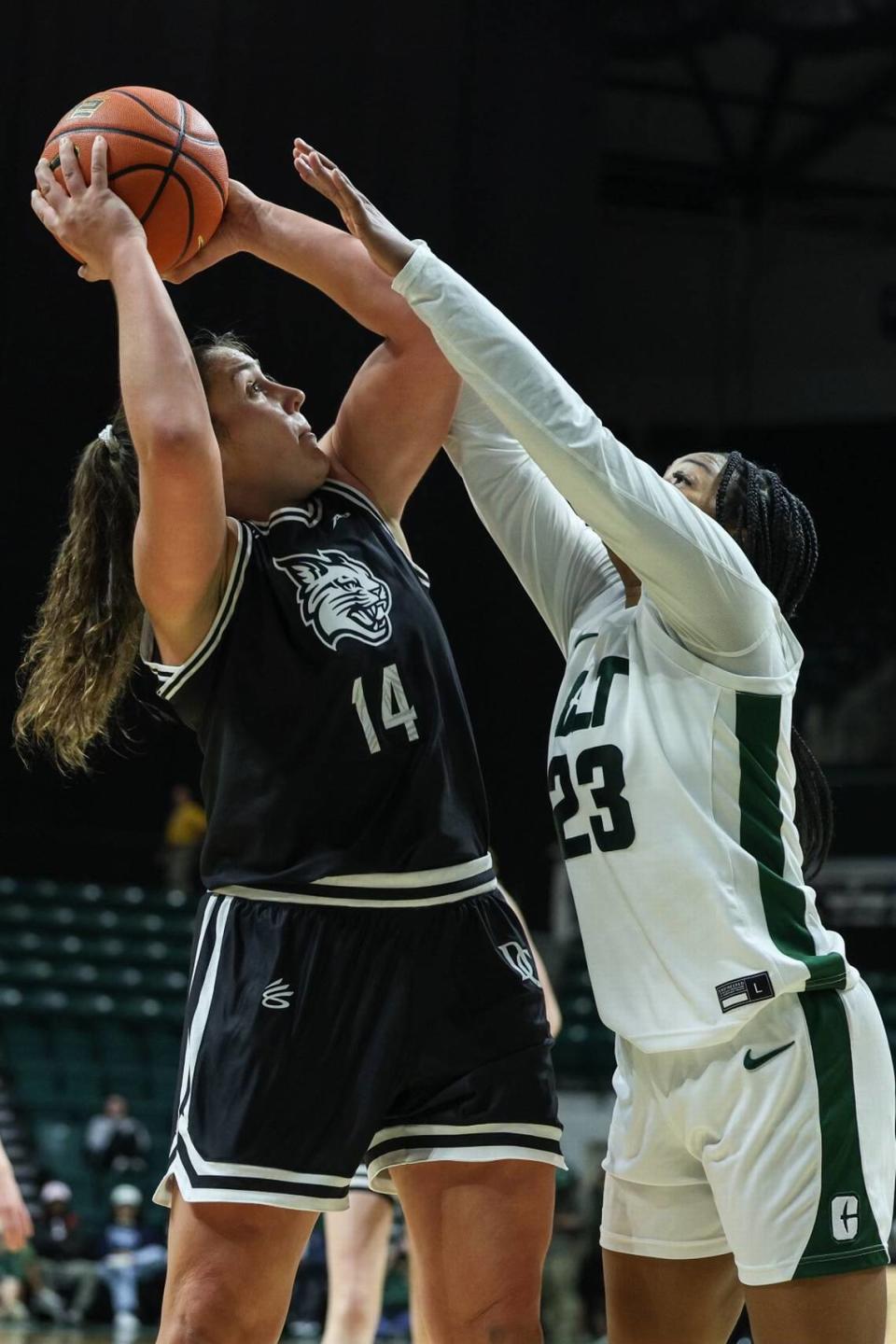 Davidson’s Maddie Plank (14) shoots over UNC-Charlotte’s Olivia Porter (23) during the game at Halton Arena on Thursday, December 21, 2023. Melissa Melvin-Rodriguez/mrodriguez@charlotteobserver.com