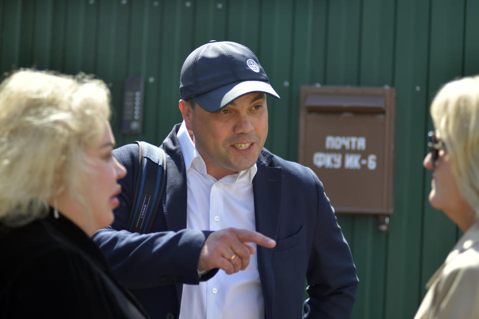 Russian opposition leader Alexei Navalny's lawyers Olga Mikhailova, right, and Vadim Kobzev, center, talk to each other as they wait to enter the colony to attend a court hearing in Melekhovo, Russia, Tuesday, June 6, 2023. A preliminary hearing will take place in a new case against opposition figure Alexei Navalny at a prison where he is held. (AP Photo)