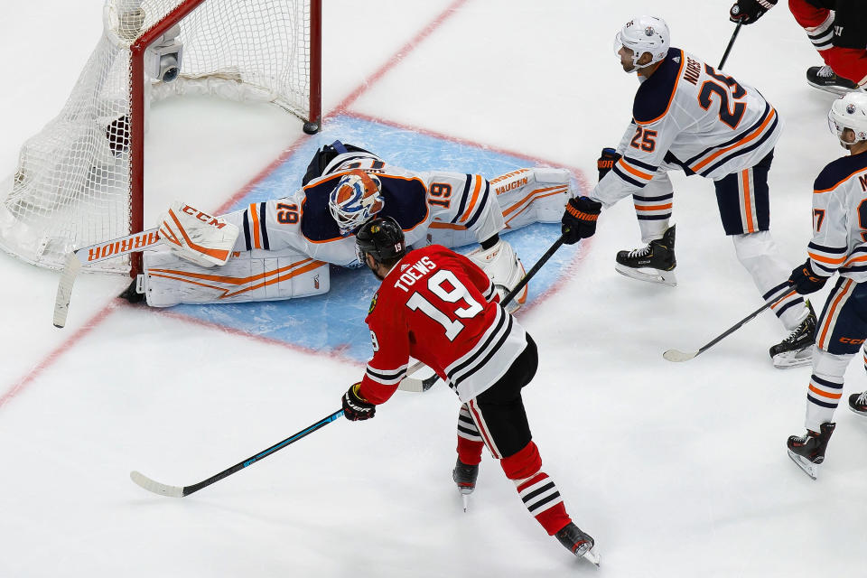 Edmonton Oilers goaltender Mikko Koskinen (19) makes a save against Chicago Blackhawks' Jonathan Toews (19) during the third period of an NHL hockey playoff game Wednesday, Aug. 5, 2020, in Edmonton, Alberta. (Codie McLachlan/The Canadian Press via AP)