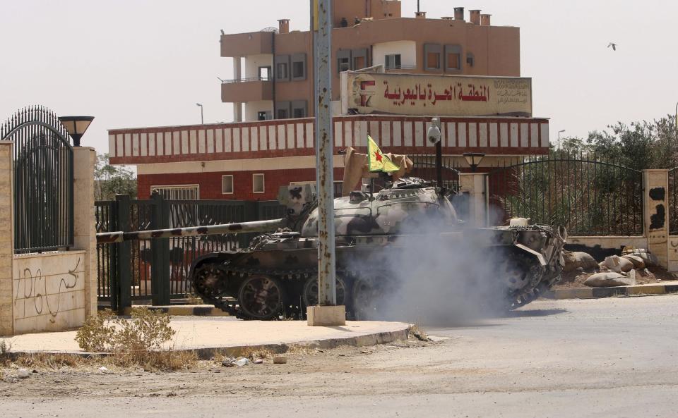 REFILE - CORRECTING LOCATION OF BORDER TOWN A Kurdish People's Protection Units (YPG) tank is driven during clashes with forces loyal to the Islamic State in the Syrian-Iraqi border town of Elierbeh of al-Hasakah Governorate August 5, 2014. Picture taken August 5, 2014. REUTERS/Rodi Said (SYRIA - Tags: POLITICS CIVIL UNREST CONFLICT)