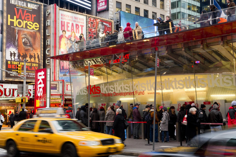 FILE - People wait in line at the Times Square TKTS discount ticket booth in New York on Jan. 19, 2012. The TKTS booth in Times Square, which has become part of the city's visual and financial DNA and a key part in keeping Broadway going, celebrates its 50th birthday this week. (AP Photo/Charles Sykes, File)