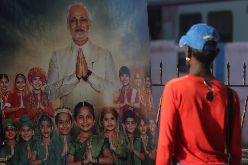 FILE PHOTO: A man looks at the poster of upcoming film "PM Narendra Modi" outside a theater in Mumbai