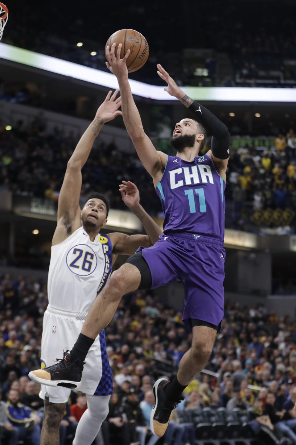 Charlotte Hornets' Cody Martin (11) shoots against Indiana Pacers' Jeremy Lamb (26) during the first half of an NBA basketball game, Sunday, Dec. 15, 2019, in Indianapolis. (AP Photo/Darron Cummings)