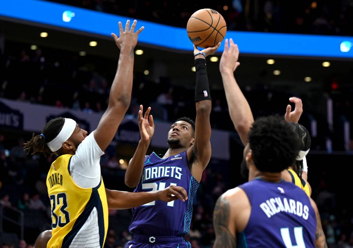 Charlotte Hornets forward/guard Brandon Miller, center, releases a shot in the lane over Indiana Pacers center Myles Turner, left, during first half action at Spectrum Center in Charlotte, NC on Monday, February 12, 2024.