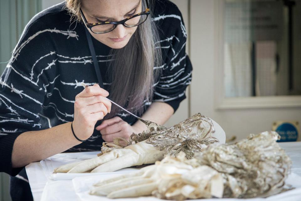 The Conservation Studio, showing Kirstin Ingram (Textile Conservation Intern) preparing white leather gloves, part of the Garter Robes ensemble worn by John Stuart (1761), for the Crown to Couture exhibition. Crown to Couture, a major exhibition at Kensington Palace, examines and celebrates how fashion from the royal Georgian court has inspired red-carpet catwalk designs in the 21st century. Crown to Couture 5th April – 29th October 2023.