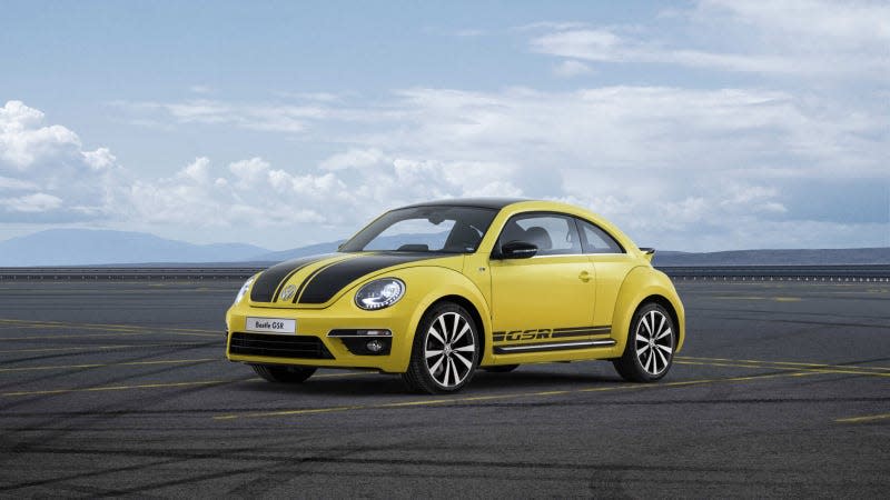A photo of a yellow VW Beetle on a race track. 