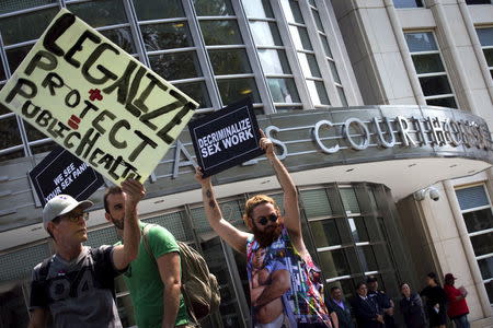 Demonstrators hold signs as they protest the arrests of male escort service Rentboy.com staffers outside United States Court in the Brooklyn borough of New York City, September 3, 2015. REUTERS/Mike Segar