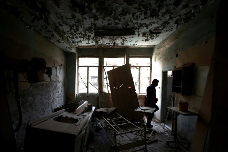 A member of a first response team walks on October 13, 2018 inside the National Hospital, which was the final bastion of IS fighters in the northern Syria city of Raqa