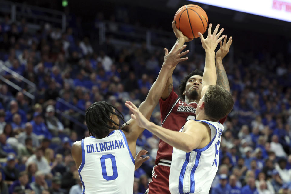 New Mexico State's Jordan Rawls, top right, shoots while pressured by Kentucky's Rob Dillingham (0) and Reed Sheppard, bottom right, during the second half of an NCAA college basketball game in Lexington, Ky., Monday, Nov. 6, 2023. (AP Photo/James Crisp)