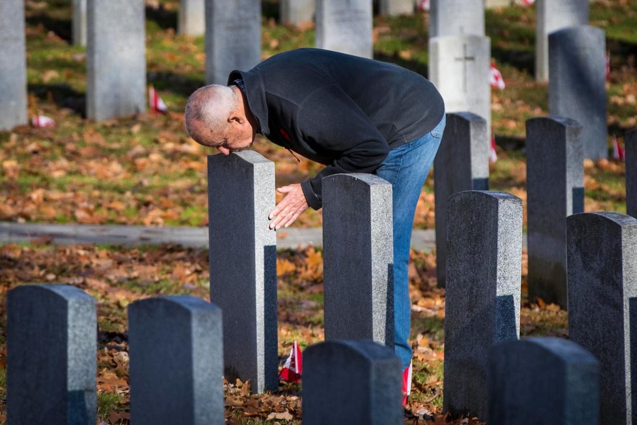 Peter Dawe kisses his son Capt. Matthew Dawe’s gravestone in Kingston, Ont., on Nov. 10, 2020. Capt. Dawe died in Afghanistan on July 4, 2007. (Lars Hagberg/Canadian Press - image credit)