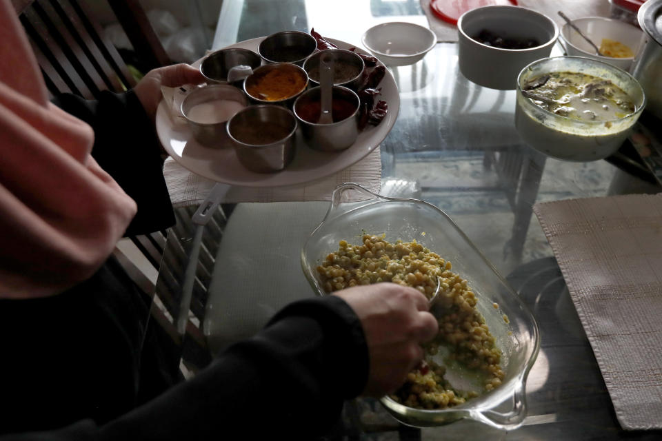 In this Tuesday, April 28, 2020, photo, Shaheen Khan gathers food for the Iftar, the evening meal with which Muslims end their daily Ramadan fast at sunset at her Wheeling,Ill., home. During the COVID-19 crisis, Khan now teaches virtually to her students at the Hadi School, a Montessori Islamic school in Schaumburg, Illinois, realizing the increased time at home could be used as an opportunity for reflection "to come back to our roots", and used the Prophet Mohammad traveling to a cave to meditate as an example. (AP Photo/Charles Rex Arbogast)