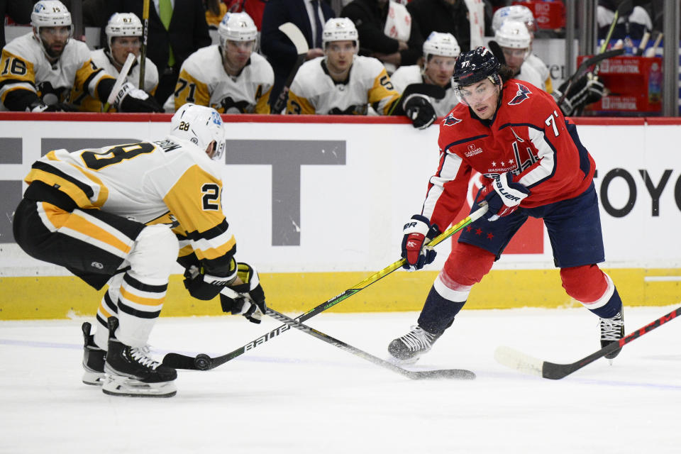 Washington Capitals right wing T.J. Oshie (77) skates with the puck against Pittsburgh Penguins defenseman Marcus Pettersson (28) during the first period of an NHL hockey game Thursday, Jan. 26, 2023, in Washington. (AP Photo/Nick Wass)