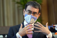 Taro Kono, Japan's minister in charge of a huge vaccination campaign, wearing a face mask speaks during an interview with The Associated Press at his office in Tokyo Wednesday, July 28, 2021. As Olympics host Tokyo saw another record number of coronavirus cases Wednesday, Kono told that the speed of the inoculation campaign, which is averaging about 10 million shots a week after a late start, is less urgent than getting shots to young people, who are blamed for spreading the virus. (AP Photo/Eugene Hoshiko)