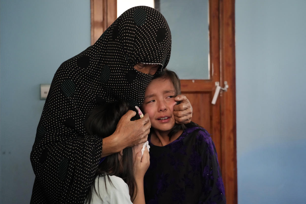 The family of a 19-years old girl who was victim of a suicide bomber mourns, in Kabul, Afghanistan, Friday, Sept. 30, 2022. A Taliban spokesman says a suicide bomber has killed several people and wounded others at an education center in a Shiite area of the Afghan capital. The bomber hit while hundreds of teenage students inside were taking practice entrance exams for university, a witness says. (AP Photo/Ebrahim Noroozi)