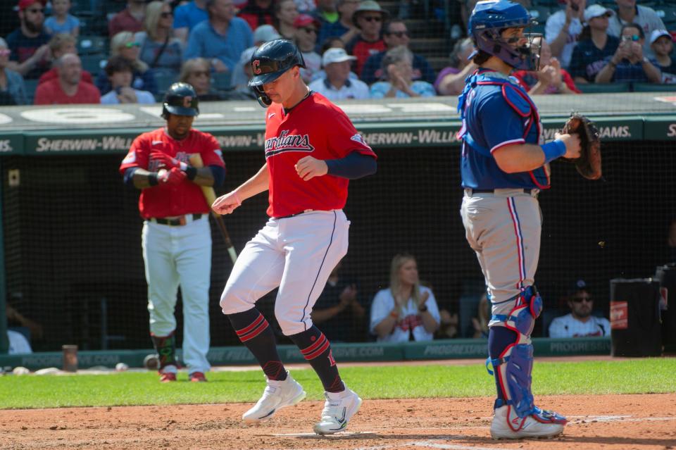 Cleveland Guardians' Will Brennan scores on a single by Steven Kwan as Texas Rangers' Austin Hedges, right, waits during the fourth inning Sunday in Cleveland.