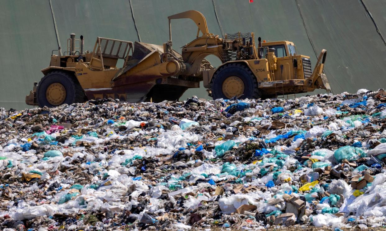 <span>Workers use heavy machinery to move trash and waste in Irvine, California, in June 2021. </span><span>Photograph: Mike Blake/Reuters</span>