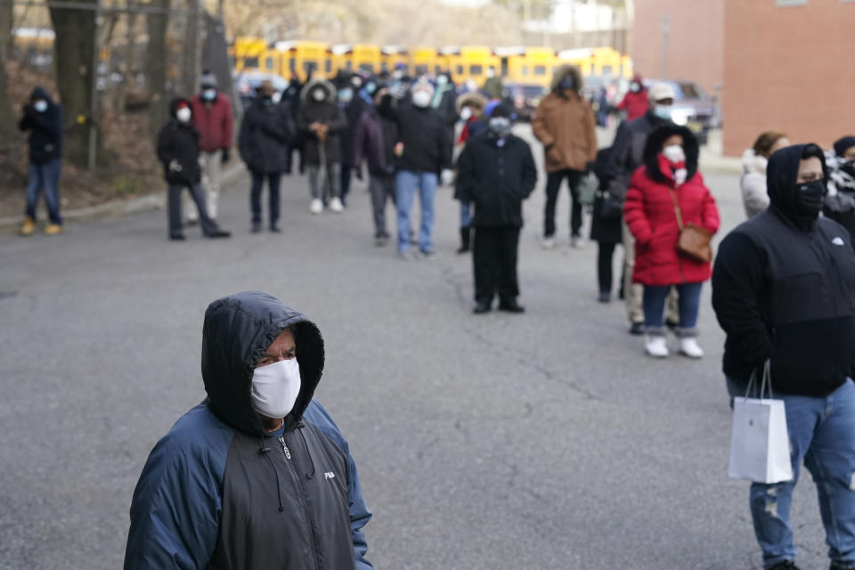 People wait in line for the COVID-19 vaccine in Paterson, N.J., Thursday, Jan. 21, 2021. The first people arrived around 2:30 a.m. for the chance to be vaccinated at one of the few sites that does not require an appointment. (AP Photo/Seth Wenig)