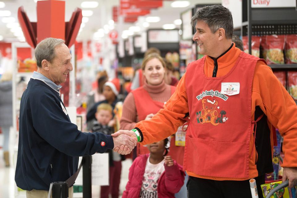 Bill Weigel shakes hands with volunteer Peter Clem.