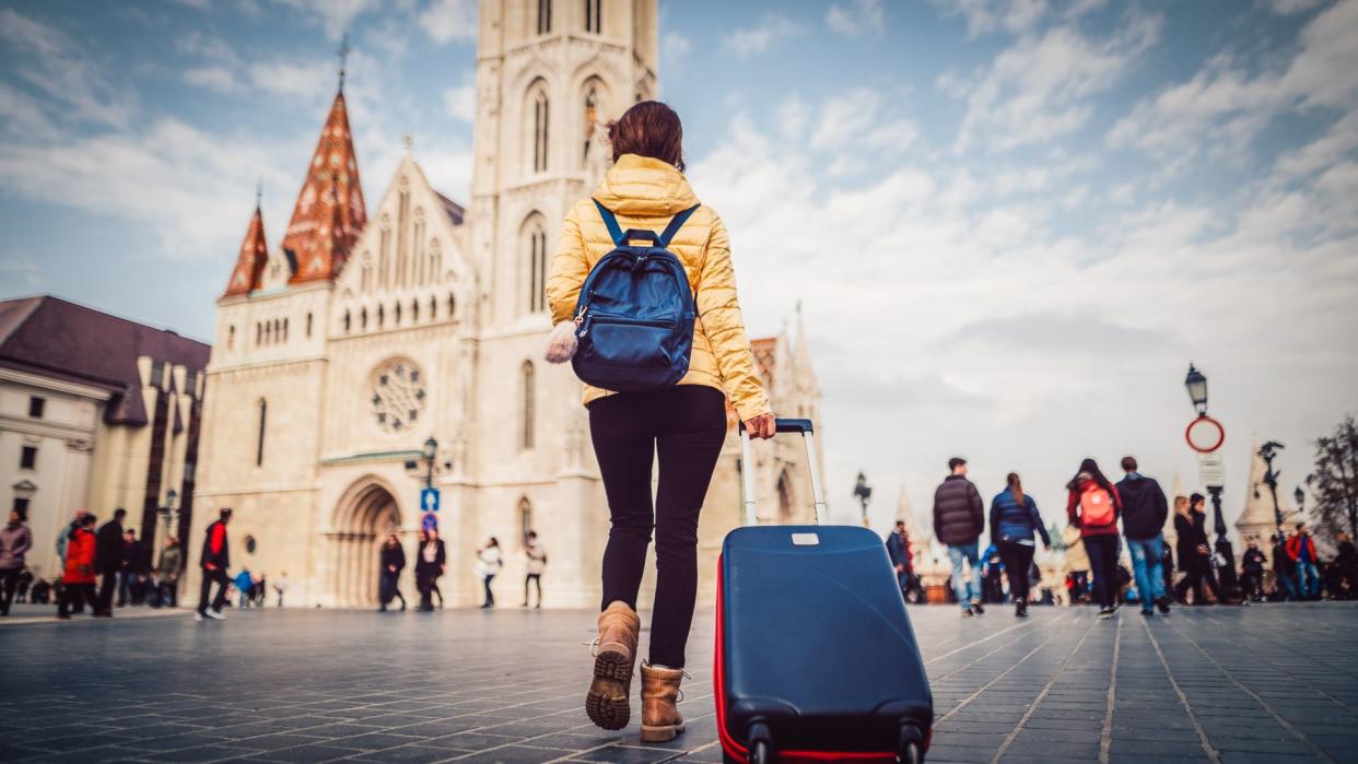 Young woman with suitcase at the castle hill-budapest.