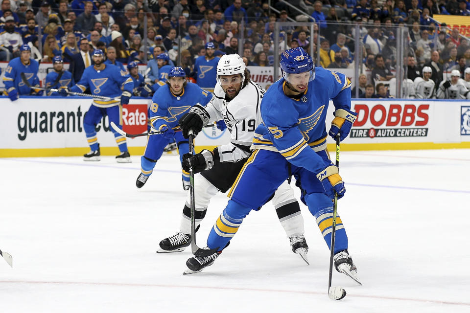 St. Louis Blues' Jordan Kyrou (25) handles the puck while under pressure from Los Angeles Kings' Alex Iafallo (19) during the second period of an NHL hockey game Saturday, Oct. 23, 2021, in St. Louis. (AP Photo/Scott Kane)