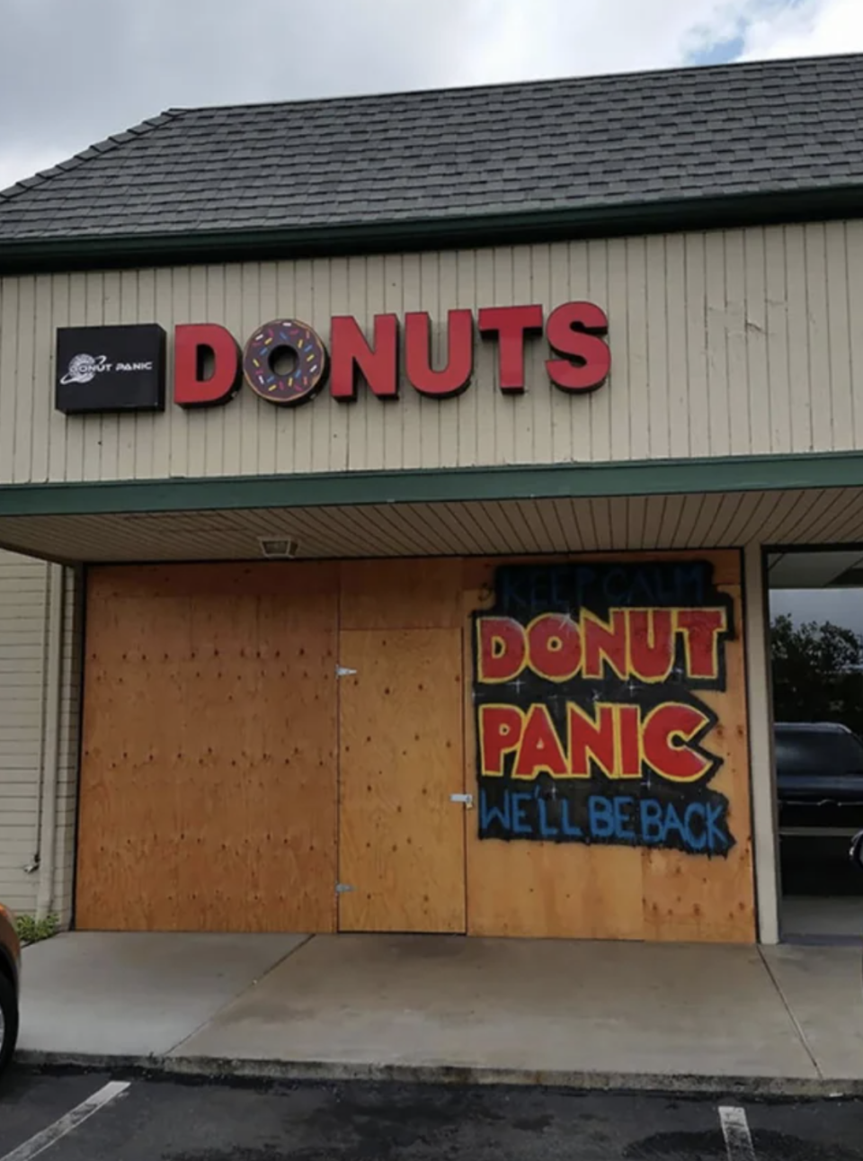 donut panic we'll be right back written on a boarded up building