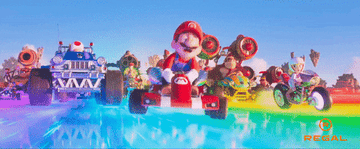 Mario leading the race on the rainbow track in front of the pack of the rest of the character's go-karts.