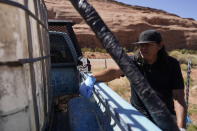 In this April 27, 2020, photo, Chris Topher Chee waits for water to fill a tank in the back of his truck to haul home in Oljato-Monument Valley, Utah, on the Navajo reservation. Even before the pandemic, people living in rural communities and on reservations were among the toughest groups to count in the 2020 census. (AP Photo/Carolyn Kaster)