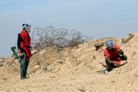 A demining team works near the village of Bitr, which in Arabic means "amputation", in Shalamjah district, east of Basra, Iraq March 4, 2018. REUTERS/Essam Al-Sudani