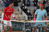 FILE - Serbia's Novak Djokovic, left, and Spain's Rafael Nadal look at each other as they pose for images prior to the final match of the French Open tennis tournament at Roland Garros stadium in Paris, France, in this Sunday, Oct. 11, 2020, file photo. When this year’s French Open starts Sunday, May 30, 2021, in Paris, Nadal will be seeking his 21st Grand Slam title to break a tie with Roger Federer for the men’s record, while Djokovic will try to close the gap with those two by earning his 19th.(AP Photo/Michel Euler, File)