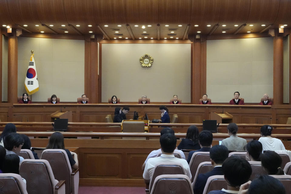 South Korea's Constitutional Court Chief Justice Lee Jong-seok, center, and other judges sit upon their arrival at the Constitutional Court in Seoul, South Korea, Thursday, Aug. 29, 2024. (AP Photo/Lee Jin-man)