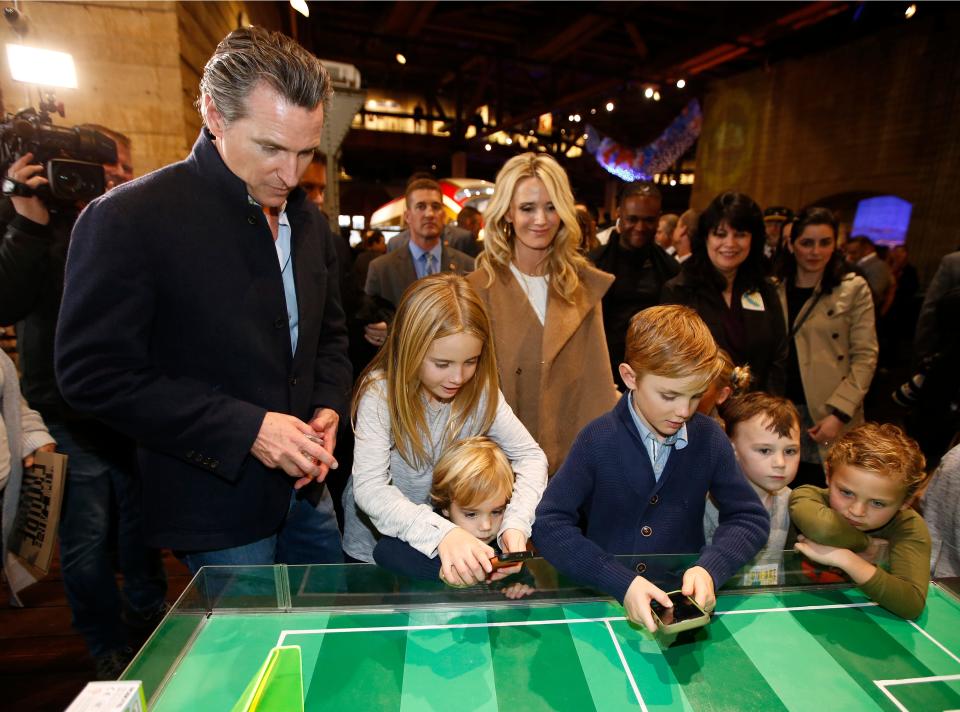 In this Jan. 6, 2019, file photo Gov. Gavin Newsom, left, and his wife, Jennifer Siebel Newsom, center, watch their children, daughter Montana, second from left, and sons, Dutch, foreground, and Hunter, foreground fourth from left, operate robot games at the California Railroad Museum, Sacramento, Calif. Newsom said this weekend that his family is under quarantine after a recent exposure to COVID-19. The governor's family tested negative for the virus on Nov. 22, 2020.