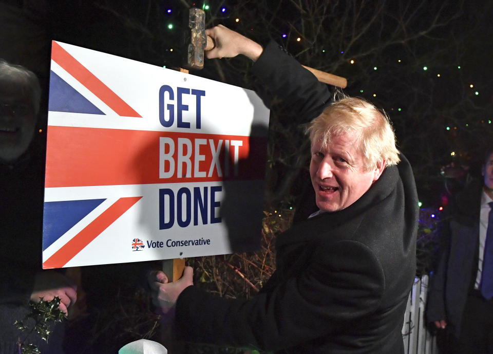 FILE - In this Wednesday, Dec. 11, 2019 file photo, Britain's Prime Minister and Conservative party leader Boris Johnson poses as he hammers a "Get Brexit Done" sign into the garden of a supporter, in Benfleet, England, on the final day of campaigning for the general election. It’s more than four years since Britain voted to leave the European Union, and almost a year since Prime Minister Boris Johnson won an election by vowing to “get Brexit done.” Spoiler alert: It is not done. As negotiators from the two sides hunker down for their final weeks of talks on an elusive trade agreement, Britain and the EU still don’t know whether they will begin 2021 with an organized partnership or a messy rivalry. (Ben Stansall/Pool Photo via AP)