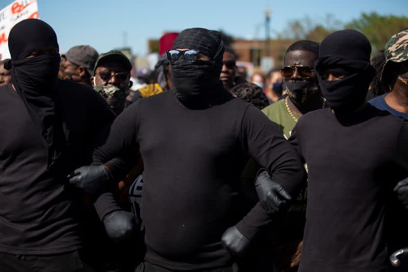 Black Panthers lock arms at the front of the march towards the Kenosha County Courthouse, in Kenosha