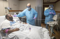 Medical personnel check the temperature of COVID-19 patient Cedric Daniels, 37, of Gonzales, La., at Our Lady of the Lake Regional Medical Center in Baton Rouge, Monday, Aug. 2, 2021. Louisiana is leading the nation in the number of new COVID cases per capita and remains one of the bottom five states in administering vaccinations. (AP Photo/Ted Jackson)