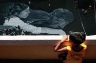 Ashly Muceros, a 10-year-old fan of Kobe Bryant, looks at the mural painted in memory of him and his daughter Gianna, hours after they died in a helicopter crash, on the basketball court of a housing tenement in Taguig City, Metro Manila