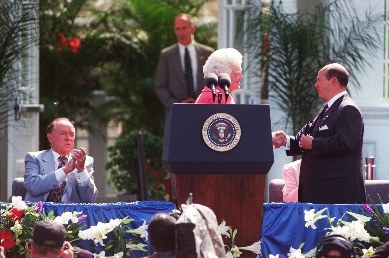 FILE --- John F. Wolfe accepts an American Flag from Barbara Bush during AmeriFlora 92 opening on April 20,1992 in Franklin Park. Bob Hope shows his approval while seated at the speakers stand. (Columbus Dispatch Photo by Mike Munden)