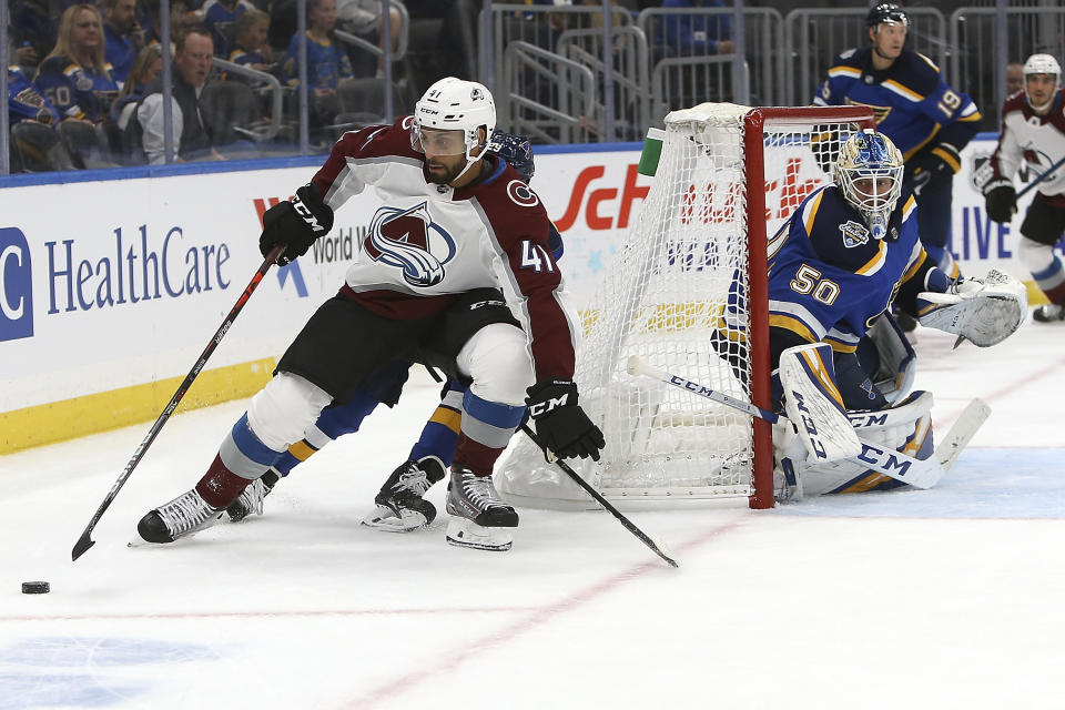 St. Louis Blues' goaltender Jordan Binnington (50) watches as Colorado Avalanche's Pierre-Edouard Bellemare (41), of France, handles the puck behind the goal during the first period of an NHL hockey game Monday, Oct. 21, 2019, in St. Louis. (AP Photo/Scott Kane)