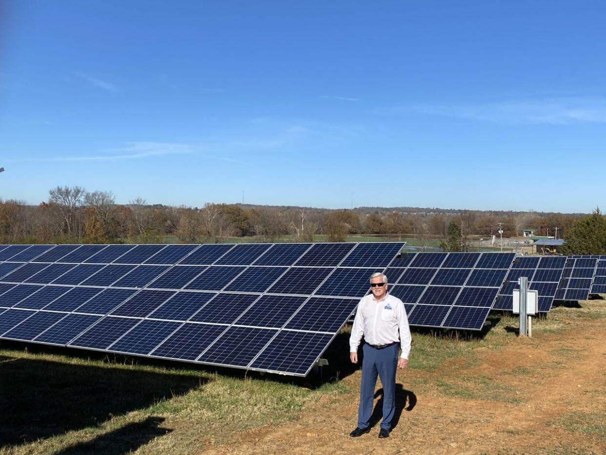 Mayor Doug Kinslow stands in front of the city's first opened solar farm.