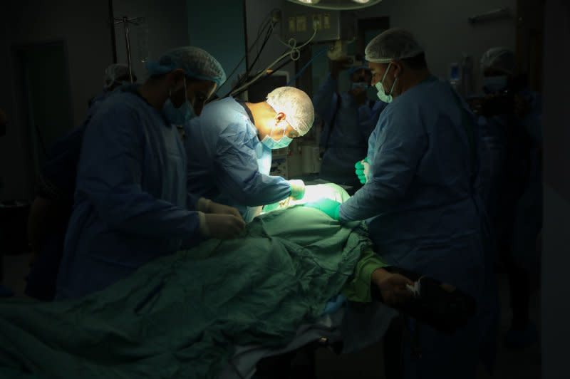 An American surgeon operates on a patient in a surgery operating theater at the European Hospital in Khan Younis in the southern Gaza Strip on Monday. Gaza's Ministry of Health said the death toll in the conflict had passed 22,000 as of Tuesday. Photo by Ismael Mohamad/UPI