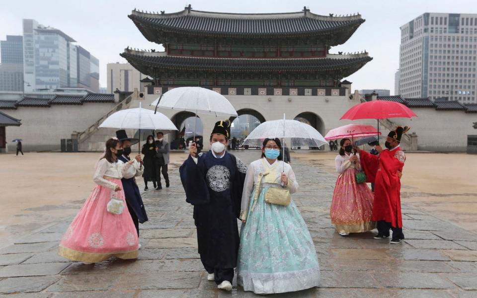 Visitors wear masks at Gyeongbok Palace in Seoul - Ahn Young-joon/AP