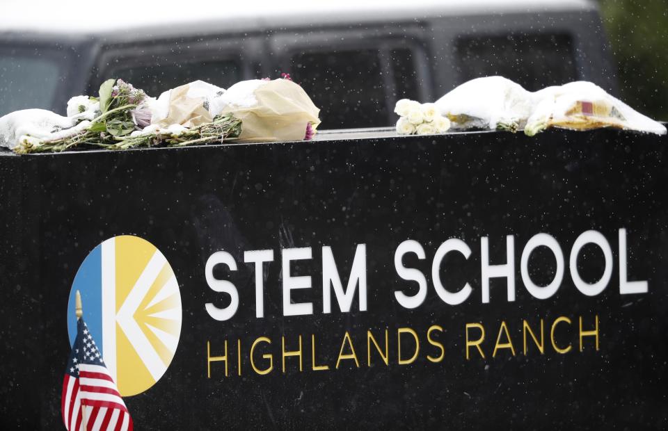 A light snow covers bouquets of flowers placed on the sign for STEM School Highlands Ranch following Tuesday's shooting, in Highlands Ranch, Colo., Thursday, May 9, 2019. (AP Photo/David Zalubowski)