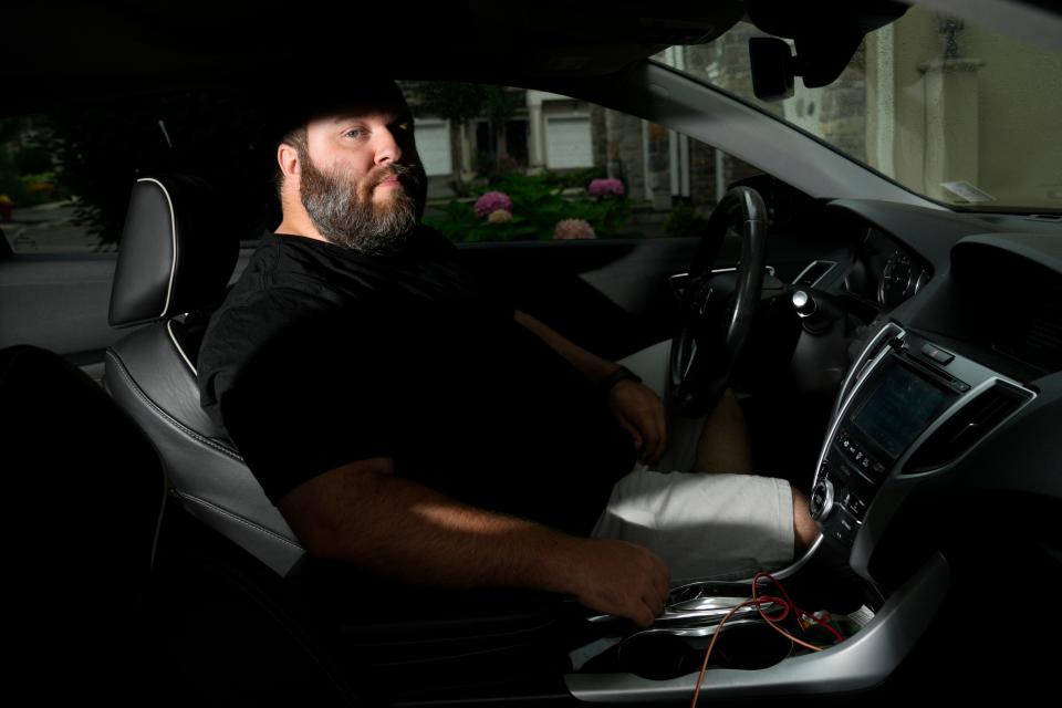 Tim DeMuth poses for a photograph inside his car, in front of his Clifton home. Wednesday, July, 19, 2023 