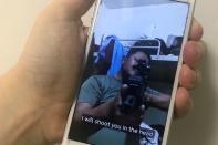 A mobile phone shows a picture of a Myanmar man in an army shirt threatening to shoot anti-coup protesters, in Singapore