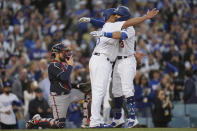 Los Angeles Dodgers' Albert Pujols hugs Chris Taylor after Taylor's two-run home run in the second inning against the Atlanta Braves in Game 5 of baseball's National League Championship Series Thursday, Oct. 21, 2021, in Los Angeles. Pujols scored on the hit. (AP Photo/Ashley Landis)