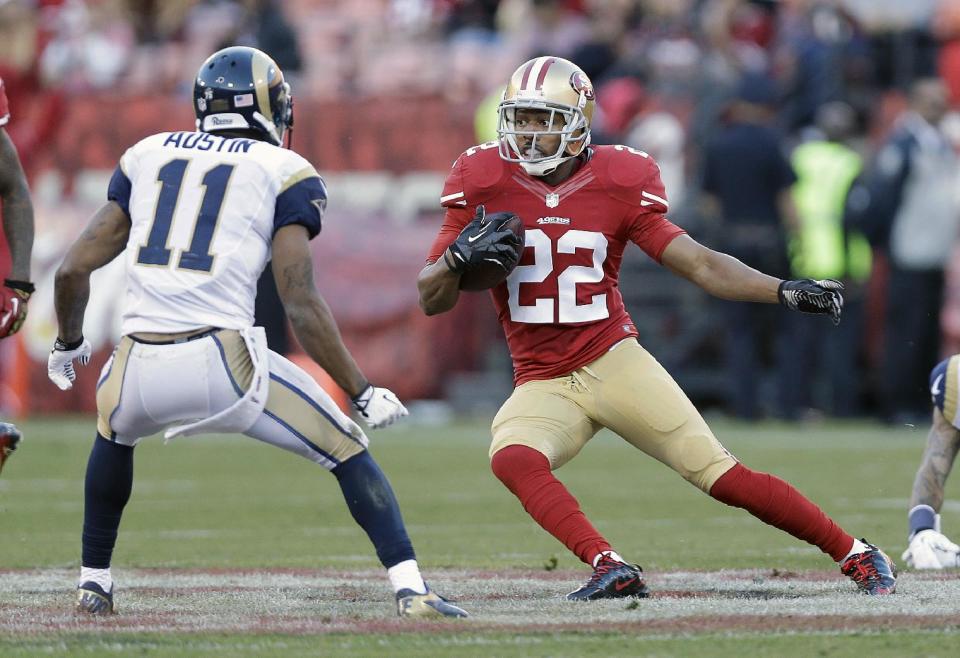 FILE - In this Dec. 1, 2013, file photo, San Francisco 49ers cornerback Carlos Rogers (22) runs against St. Louis Rams wide receiver Tavon Austin (11) after intercepting a pass from quarterback Kellen Clemens during an NFL football game in San Francisco. The 49ers have released cornerback Rogers after three seasons, an expected cost-cutting move as the NFL's free agency period begins Tuesday, March 11, 2014. (AP Photo/Marcio Jose Sanchez, File)